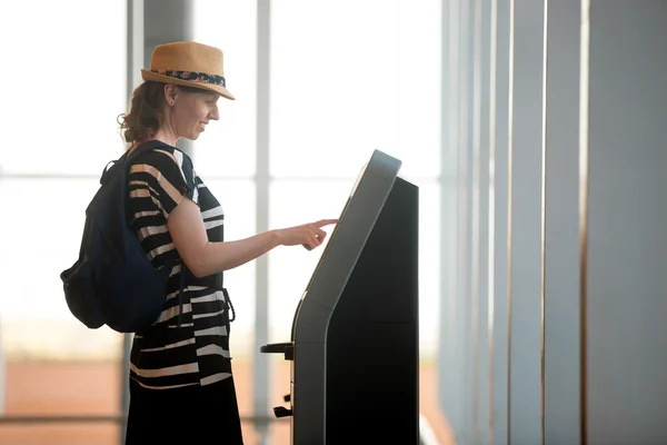 Женщина делает самостоятельной регистрации в аэропорту в — стоковое фото